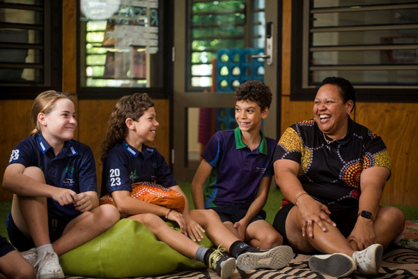 Amanda sitting with three students in a school library.