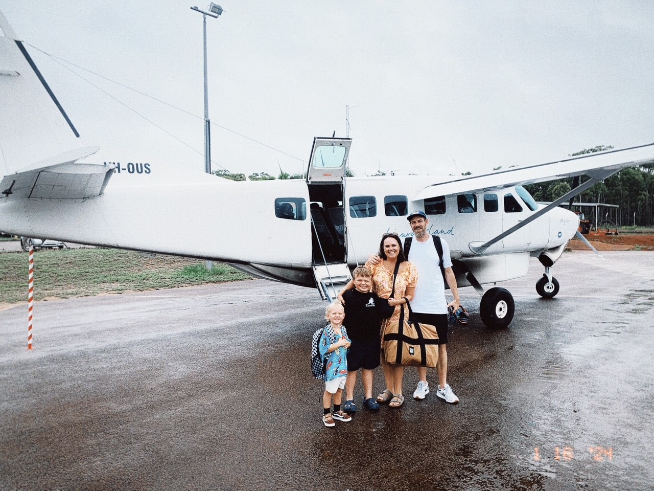 Bella and her family standing in front of a light plane.